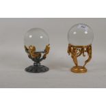 A glass ball mounted gilt metal base and another similar, 8" high