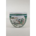 A famille vert porcelain jardiniere with decorative panels depicting figures in gardens and birds