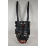 An African carved and painted wood tribal mask, 12" wide, 31" high