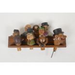 A set of four carved and painted Black Forest figural caricature bottle stoppers/pourers, in a