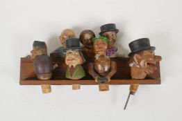 A set of four carved and painted Black Forest figural caricature bottle stoppers/pourers, in a