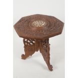 A miniature Indian table with carved and bone inlaid decoration on a folding base, 9" high