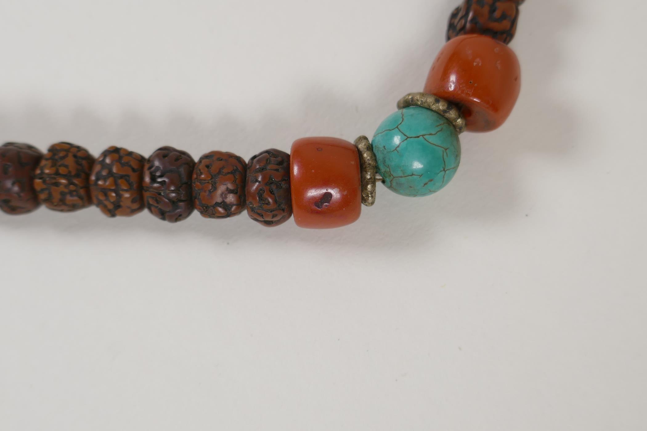 A string of Tibetan nut kernal mala beads with turquoise and coral feature beads, 33" long - Image 2 of 4