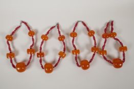 Four glass and faux amber graduated beaded necklaces, 18" long