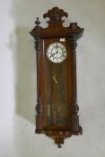 A C19th Vienna wall clock, the enamel dial with Roman numerals and a subsidiary second dial, 47"