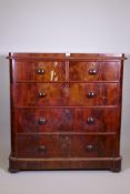 A Victorian figured mahogany chest of two over three drawers with rounded corners, raised on bun