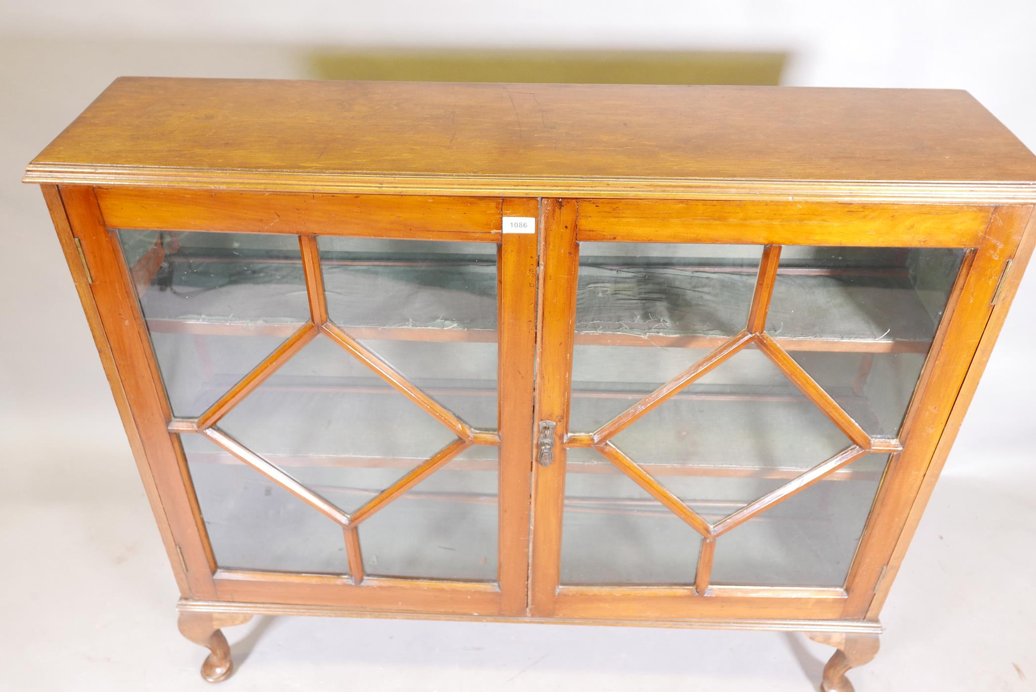 A 1930s golden walnut bookcase with two astragal glazed doors, raised on cabriole supports, 12" x - Image 2 of 2