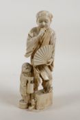 A Japanese Meiji period ivory okimono figure of a gentleman holding a fan with a child, signed to