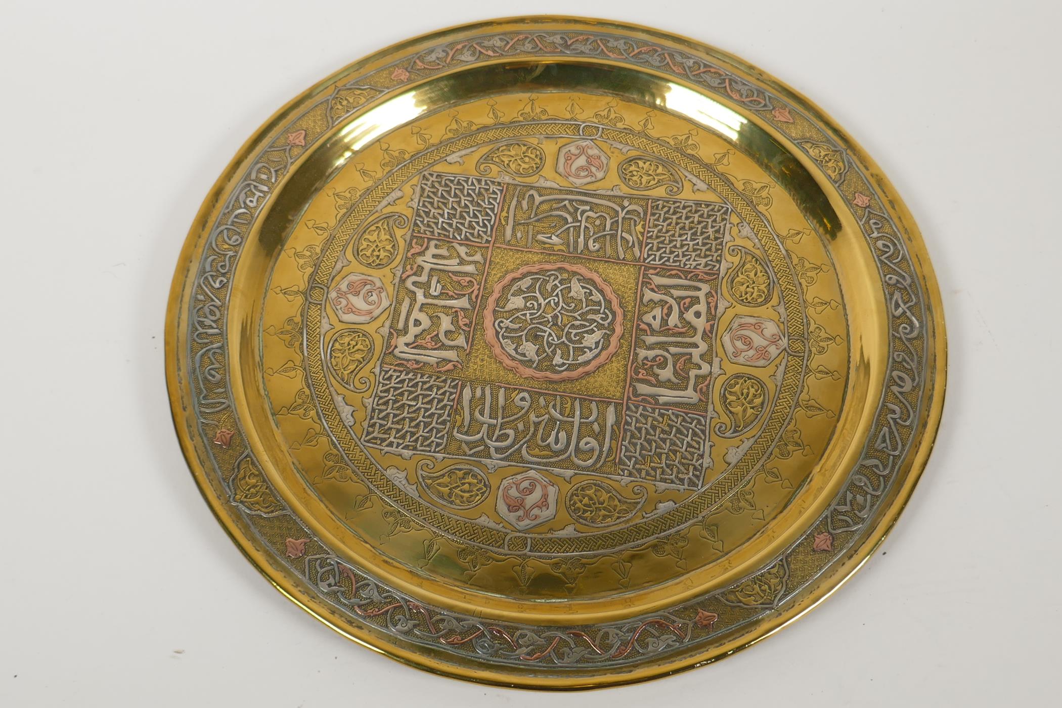 A brass Cairo ware tray decorated with copper and silver in symbols and Islamic script, 12½" - Image 2 of 3