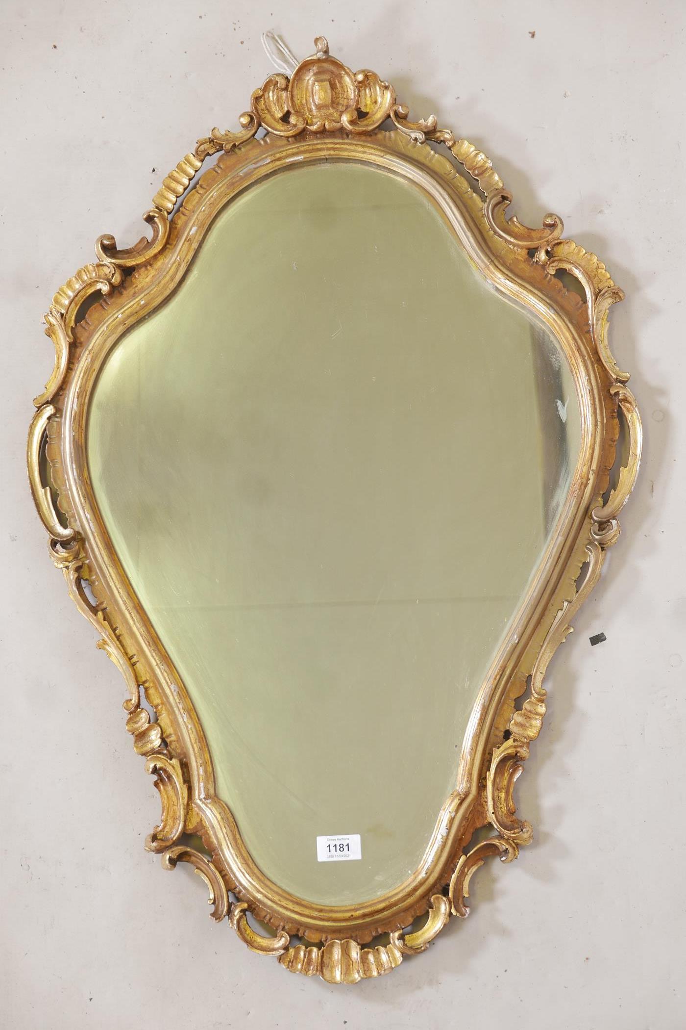A carved and pierced giltwood rococo style wall mirror, early C20th, 35" long