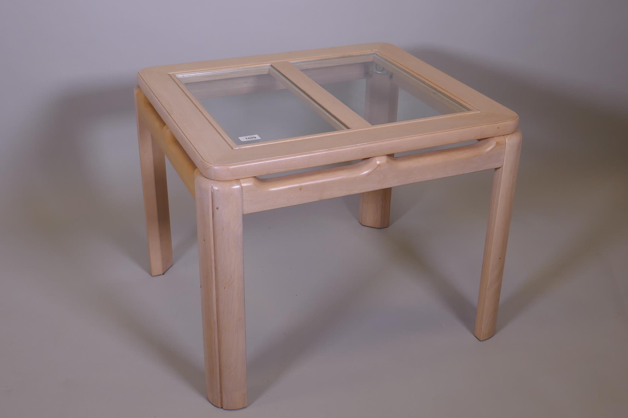 A contemporary blonde beechwood coffee table with inset glass top, 27" x 27" x 21"