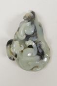 A Chinese celadon jade pendant with black inclusions, and carved kylin decoration, 2½" x 3½"