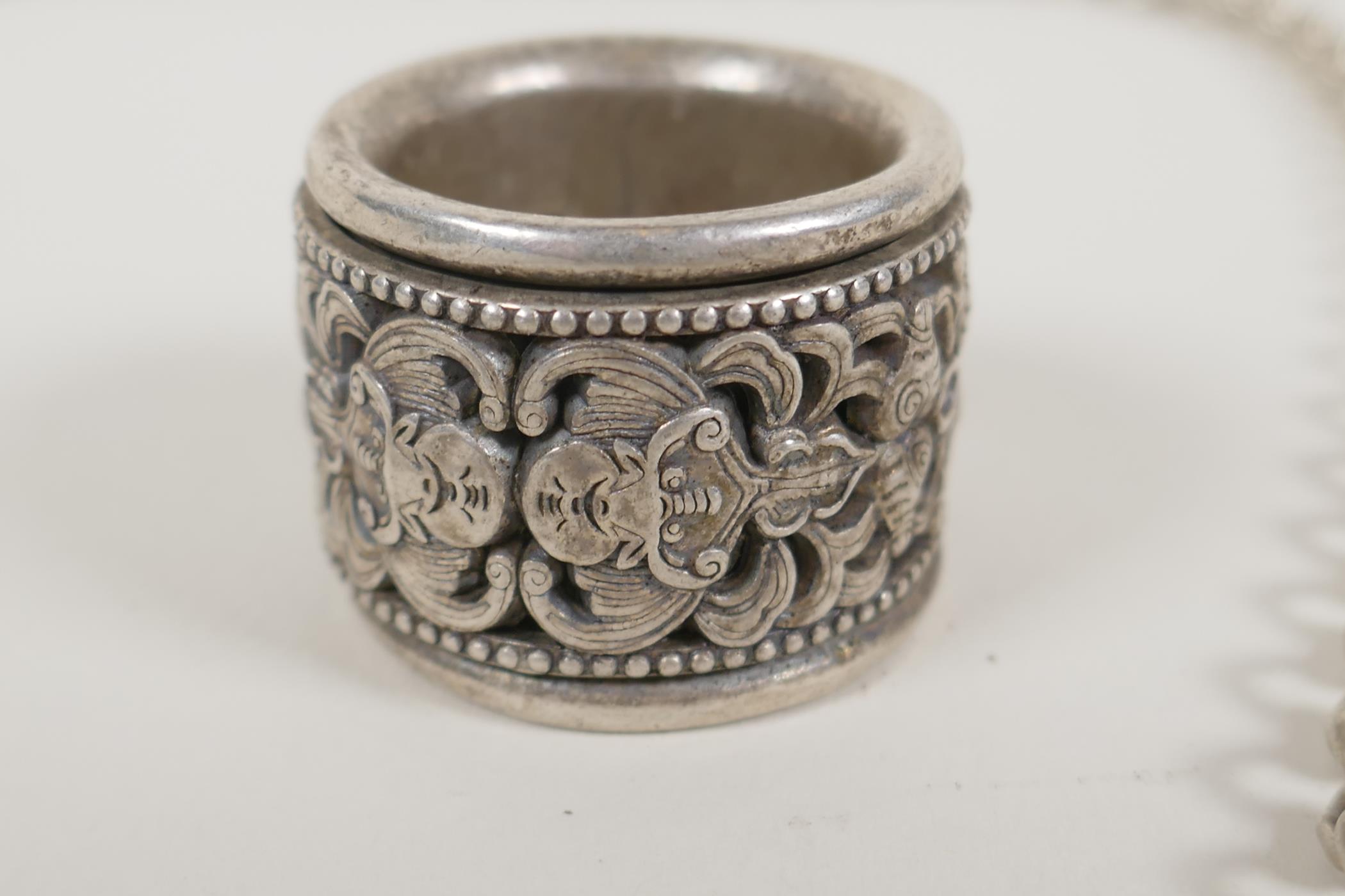 A Chinese white metal archers thumb ring, with revolving cuff decorated with bats, and a white metal - Image 3 of 4