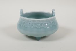 A Chinese powder blue glazed two handled porcelain censer raised on tripod supports, impressed