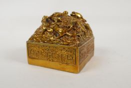 A Chinese filled gilt bronze seal, the top decorated with entwined dragons, 4" x 4"