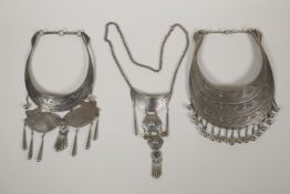 Two Indo Persian white metal chokers with engraved carp and butterfly decoration, and another