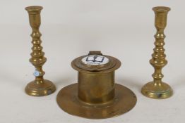 An Art Deco brass capstan inkwell with enamelled cover and a pair of miniature brass candlesticks,