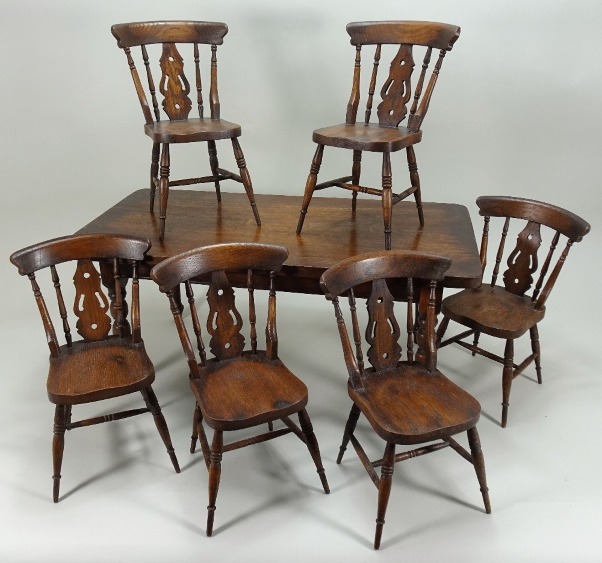 A dolls wooden dining table with six Windsor chairs, English circa 1905,