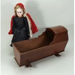 A carved and painted wooden dolls crib on rockers,