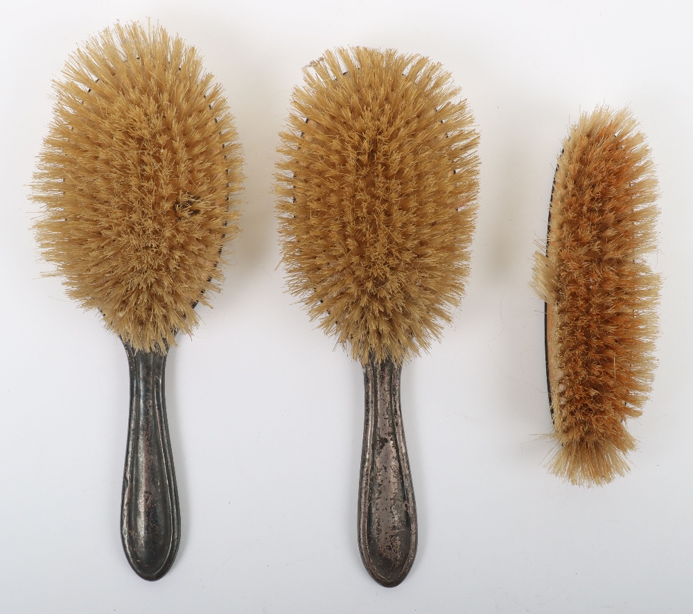 A silver dressing table brush set