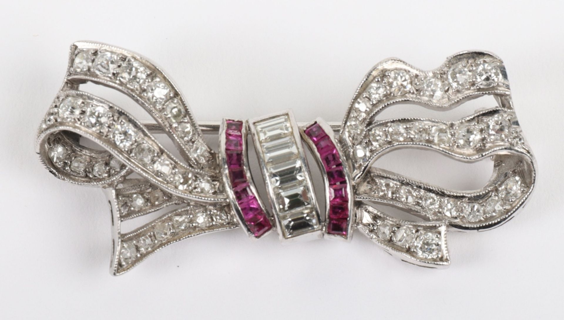 A white metal, diamond and ruby bow brooch