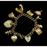 9ct gold curb chain bracelet, with heart locket clasp hallmarked and nine gold charms including duck