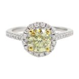 18ct white gold diamond halo ring, the central round brilliant cut fancy yellow diamond of 1.02 cara