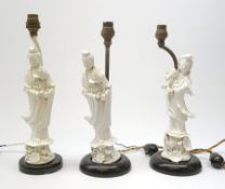 Three blanc de chine figures, modelled as Guanyin, each mounted upon a lamp base, (a/f), figures H26