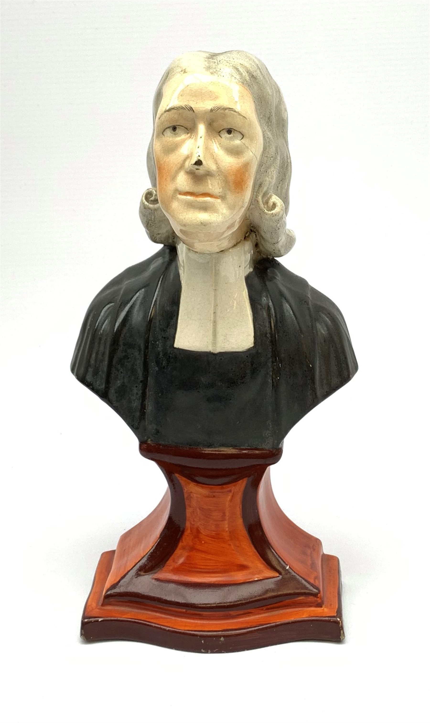 A Staffordshire bust, modelled as John Wesley, upon spreading base, H24.4cm.