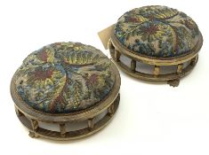 A pair of Victorian needle and beadwork footstools within a gilded frame raised upon three paw feet,