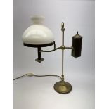 A brass students lamp, with adjustable arm supporting counter weight and white glass shade, H49cm.