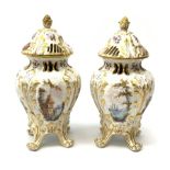 A pair of Continental porcelain vases and covers, each of baluster form raised upon four scroll feet