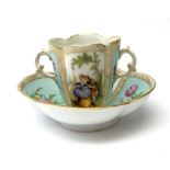 A Helena Wolfsohn Dresden porcelain quatrefoil twin handled chocolate cup and stand, painted with pa