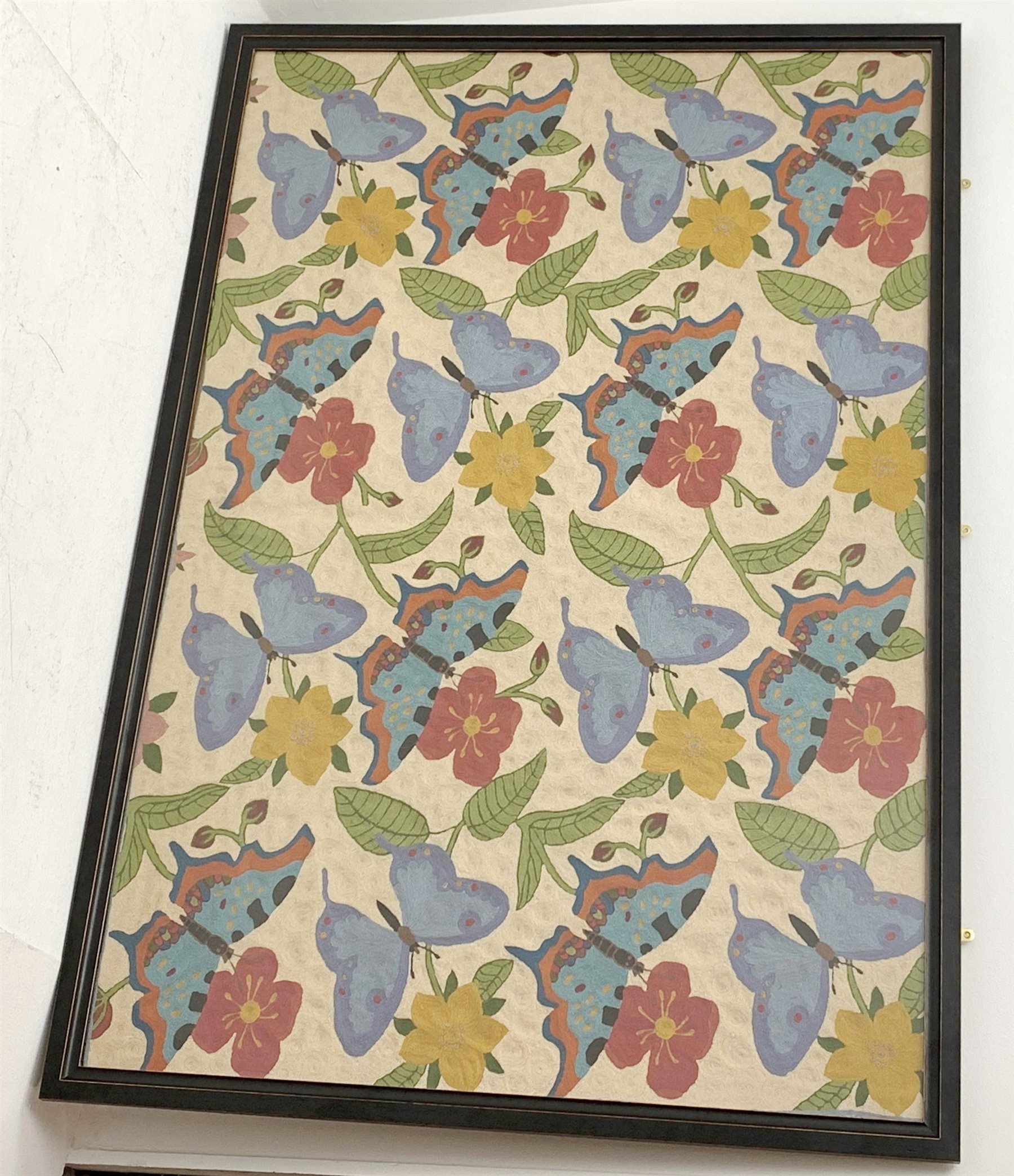 A large framed and glazed crewelwork embroidery, depicting butterflies amidst flowering vines, upon