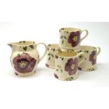 Four Emma Bridgewater mugs, together with a matching jug, each decorated with purple flowers upon a