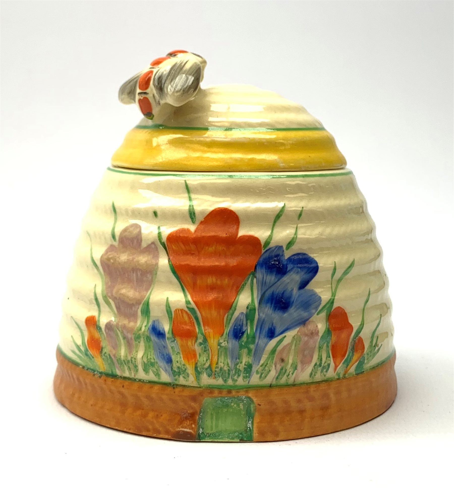 A Clarice Cliff Newport Pottery honey pot, modelled in the form of a beehive and decorated in the Cr