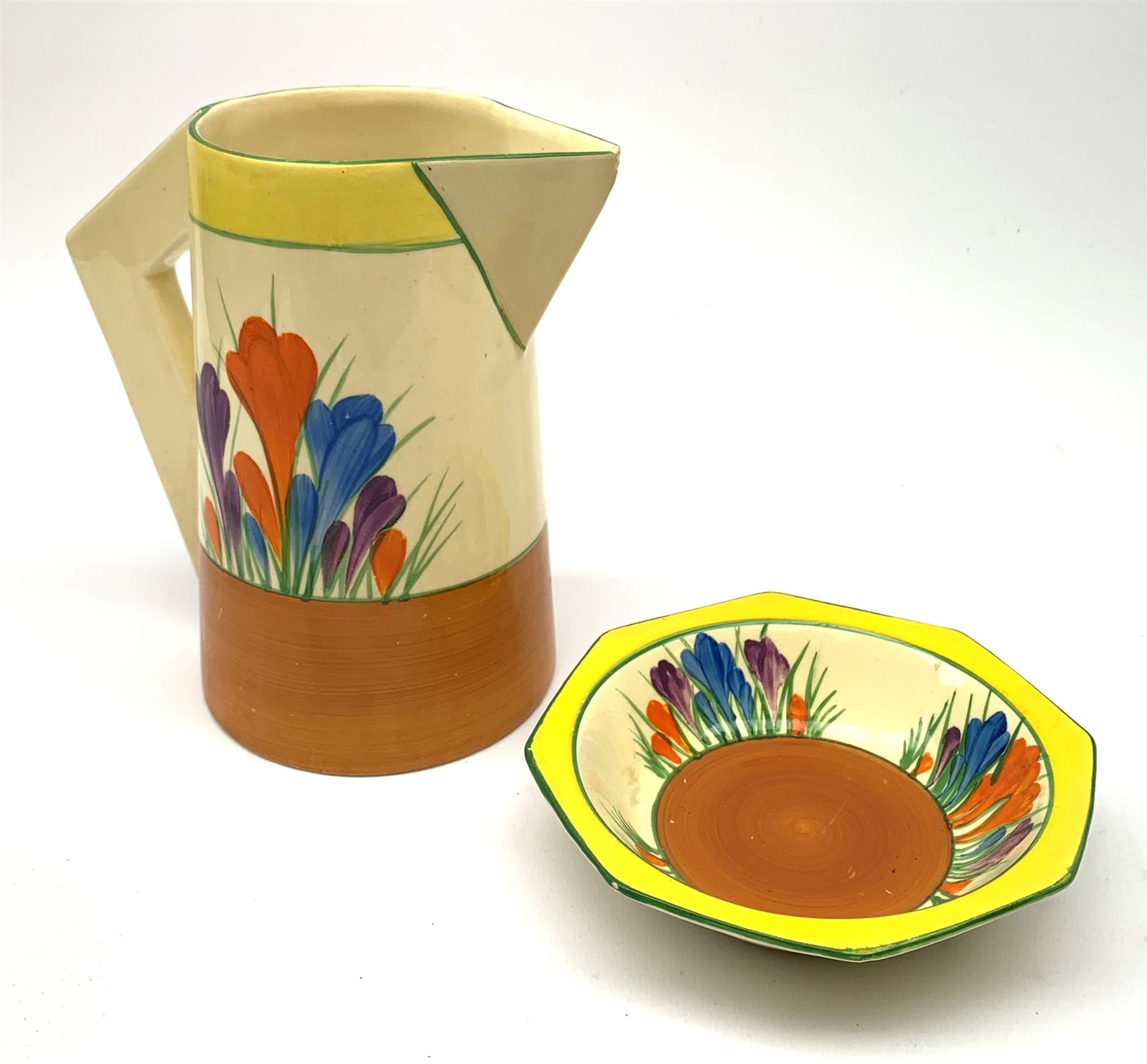 A Clarice Cliff Newport Pottery jug, decorated in the Crocus pattern, H16.5cm, together with a Clari