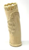 An African carved ivory spill vase, of cylindrical form with pierced rim and gadrooned band to base,