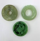 Two jadeite bi discs, largest D5.5cm, together with a nephrite jade disc with carved zoomorphic deta