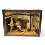 A 1/12th scale diorama of a cottage sitting room, depicting an elderly lady seated before a fireplac