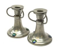 A pair of German pewter candlesticks, the circular bases with applied cabouchons, leading to a plann