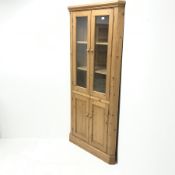 Solid pine corner cabinet, projecting cornice, two glazed doors enclosing two shelves above two cupb