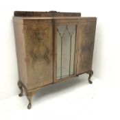 Early 20th century figured walnut side cabinet, shaped moulded top over central glazed door and two