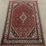 Large Persian red ground rug, central medallion, repeating border, 315cm x 210cm