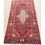 Hamadan red ground rug, repeating border, central medallion, 325cm x 170cm