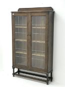 Early 20th century oak bookcase enclosed by two lead glazed doors, fitted with three adjustable shel