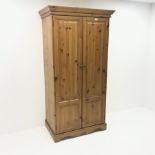 Solid pine double wardrobe, projecting cornice, two doors enclosing fitted interior, shaped plinth b