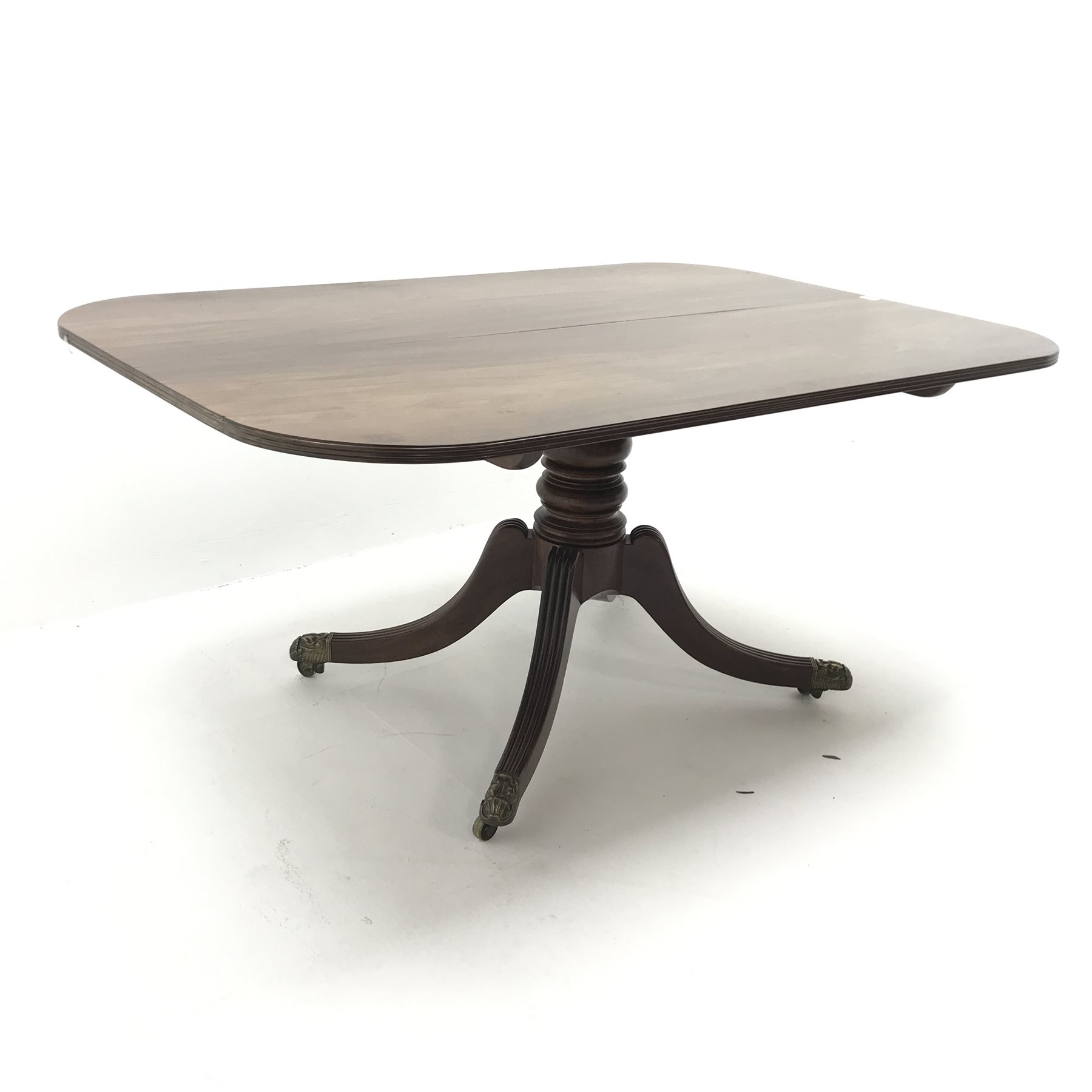 Regency mahogany tilt top table, single turned column on four shaped and reeded brass capped support