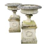 Pair composite stone urns on square plinths