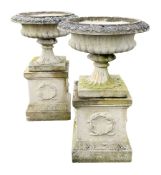 Pair composite stone urns on square plinths